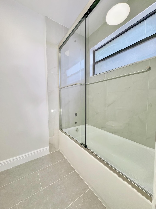 bathroom featuring tile patterned floors and bath / shower combo with glass door