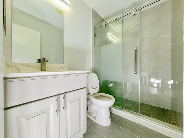 bathroom with tile patterned floors, vanity, toilet, and walk in shower