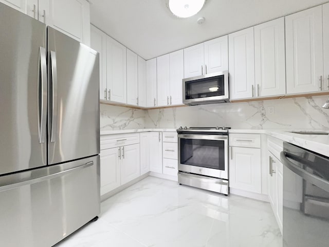 kitchen featuring white cabinets, backsplash, light stone countertops, and stainless steel appliances