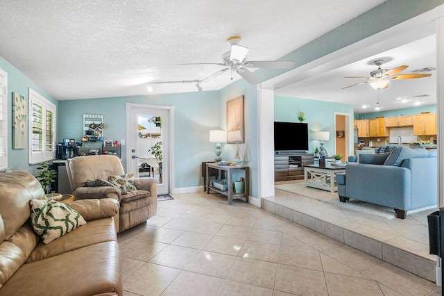 tiled living room featuring ceiling fan, lofted ceiling, and a textured ceiling