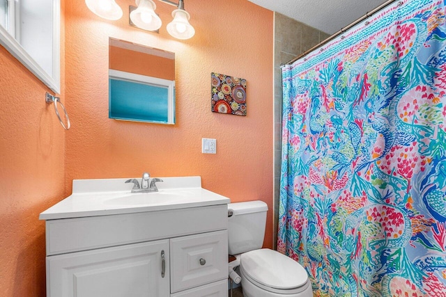 bathroom featuring vanity, toilet, a textured ceiling, and walk in shower