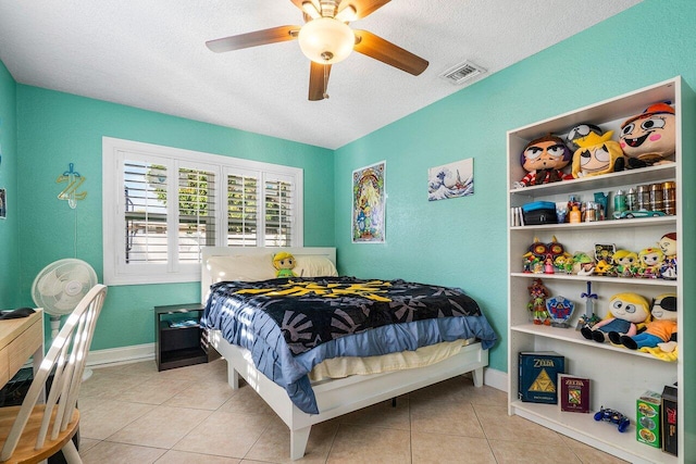 bedroom featuring a textured ceiling, ceiling fan, and light tile patterned flooring