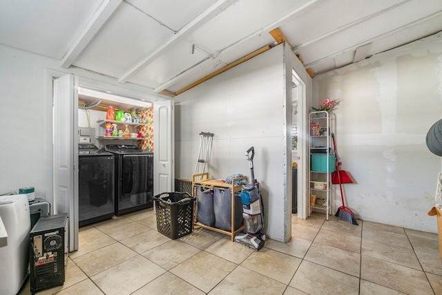 laundry area with independent washer and dryer and light tile patterned flooring