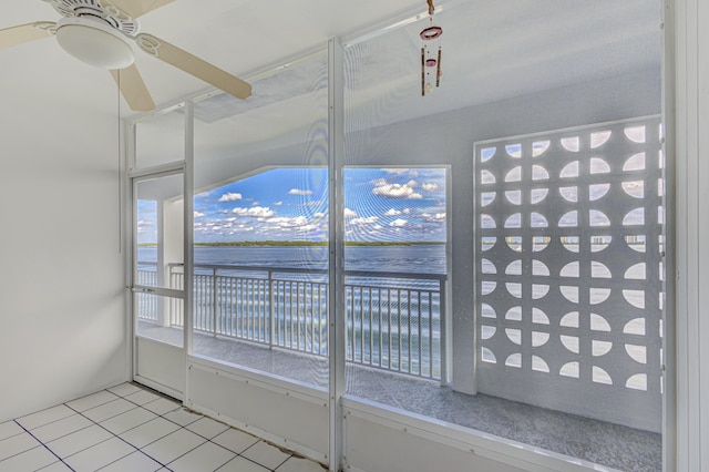 unfurnished sunroom with ceiling fan and a water view