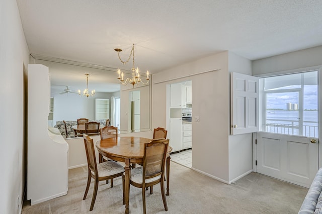 carpeted dining space featuring ceiling fan with notable chandelier