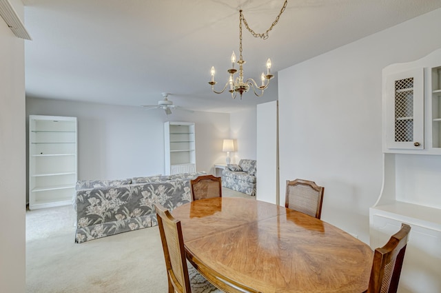 dining room featuring carpet flooring and ceiling fan with notable chandelier