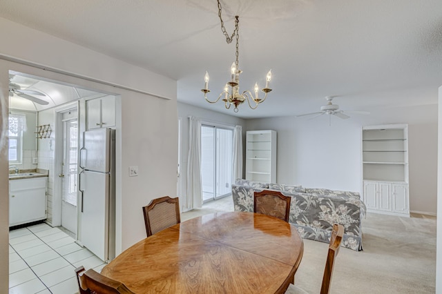 carpeted dining room featuring ceiling fan with notable chandelier, a healthy amount of sunlight, and built in features