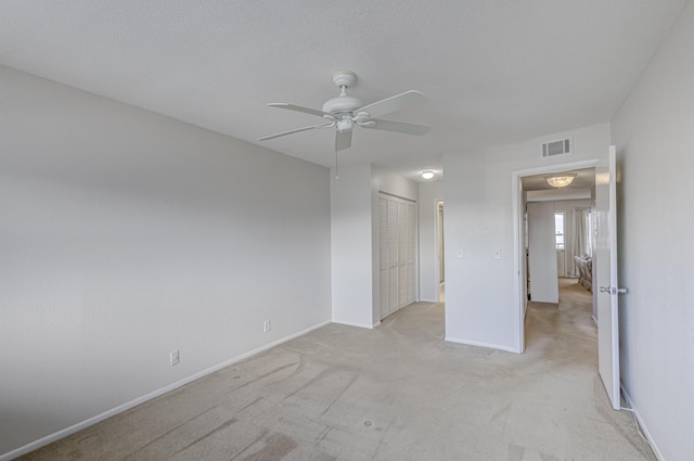 unfurnished bedroom with ceiling fan, a closet, and light carpet