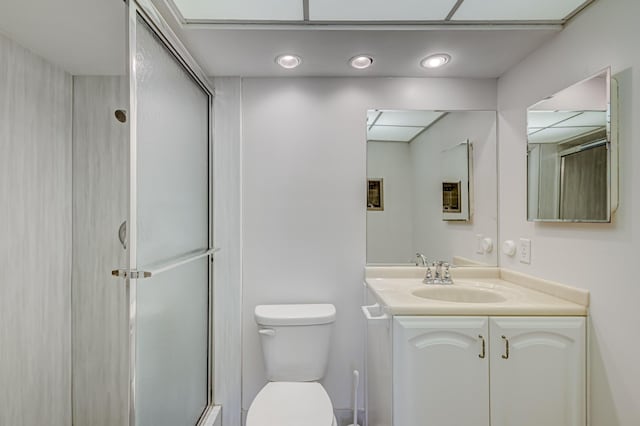 bathroom with walk in shower, vanity, and toilet