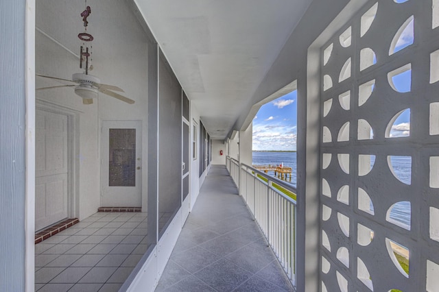 balcony featuring a water view and ceiling fan