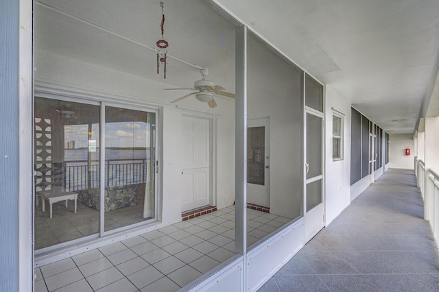 unfurnished sunroom featuring ceiling fan