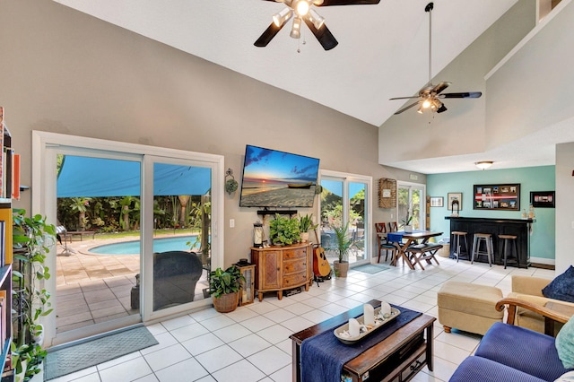 tiled living room featuring ceiling fan and high vaulted ceiling