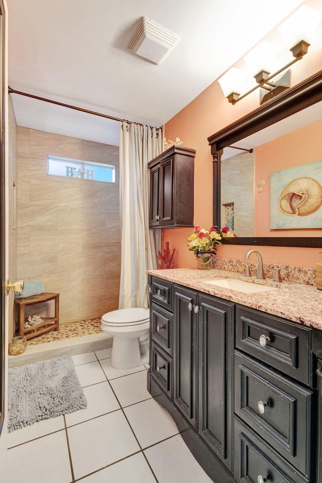 bathroom featuring toilet, vanity, tile patterned floors, and a shower with shower curtain