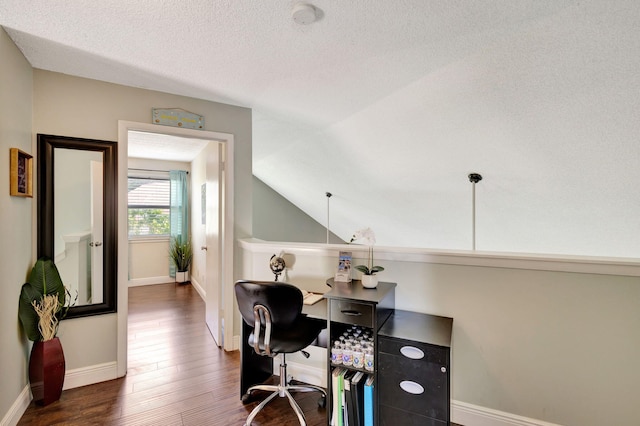 home office featuring a textured ceiling, dark wood-type flooring, and lofted ceiling