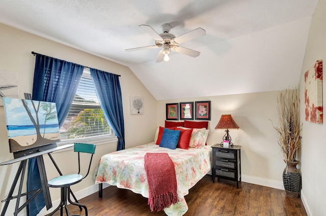 bedroom with ceiling fan, dark hardwood / wood-style floors, a textured ceiling, and vaulted ceiling