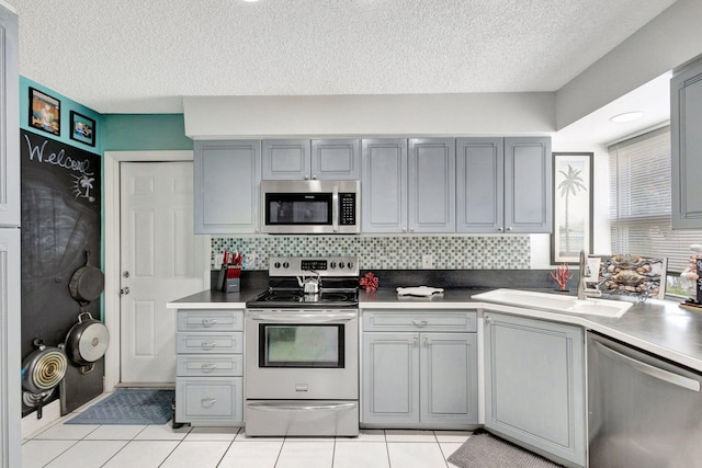 kitchen featuring stainless steel appliances, gray cabinets, and sink