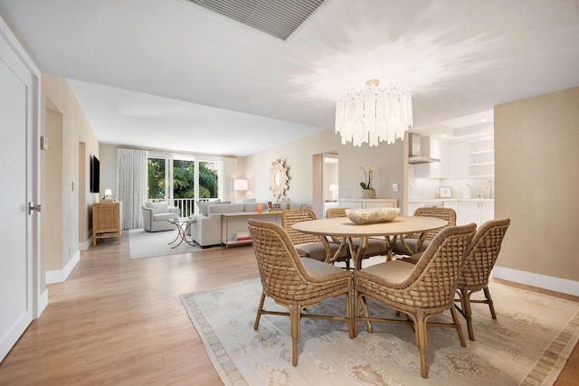 dining room with light wood-type flooring and a chandelier