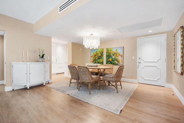 dining area featuring light wood-type flooring and a chandelier