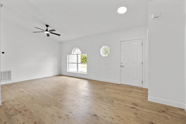 interior space featuring ceiling fan, vaulted ceiling, and light wood-type flooring