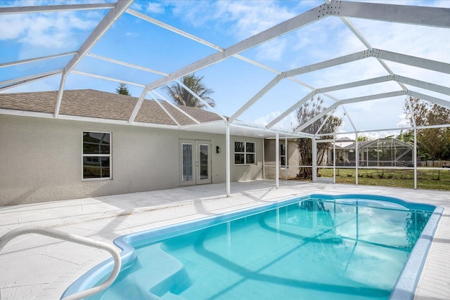 view of pool with french doors, a patio area, and a lanai