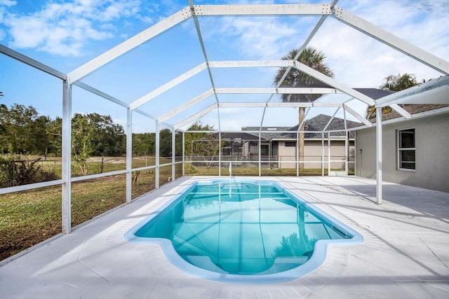 view of swimming pool featuring glass enclosure and a patio area