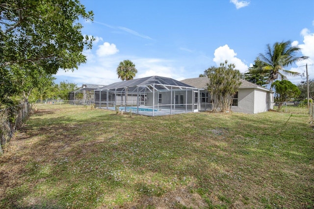 back of house with glass enclosure and a yard