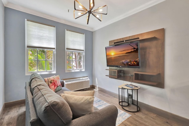 living room featuring hardwood / wood-style floors, ornamental molding, a wall mounted air conditioner, and a notable chandelier