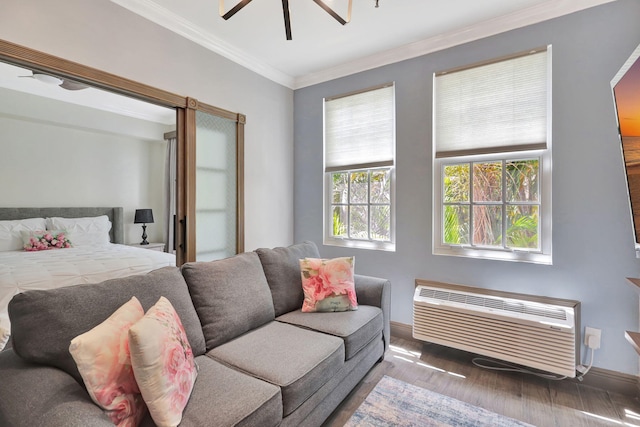 bedroom with hardwood / wood-style floors, an AC wall unit, ceiling fan, and crown molding