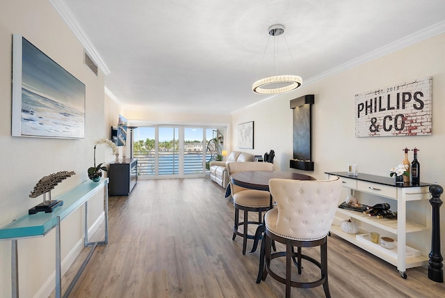 dining area featuring crown molding and hardwood / wood-style flooring