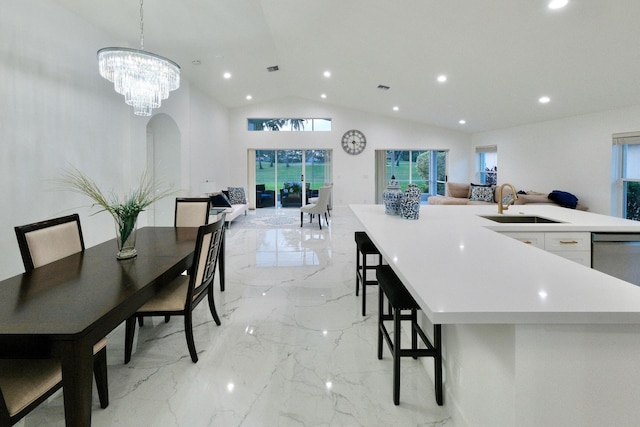 kitchen featuring a kitchen island with sink, sink, hanging light fixtures, vaulted ceiling, and white cabinetry