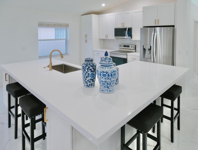 kitchen with appliances with stainless steel finishes, a kitchen breakfast bar, a large island, and sink