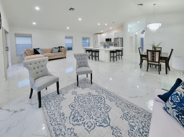 living room featuring lofted ceiling and a chandelier