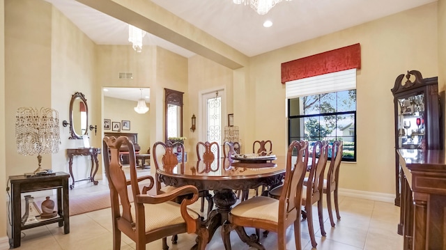 tiled dining room featuring an inviting chandelier