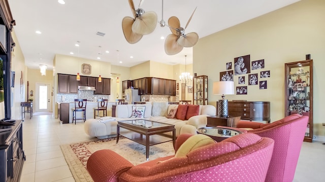 living room featuring light tile patterned floors and ceiling fan with notable chandelier