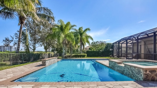 view of swimming pool featuring a lanai and an in ground hot tub