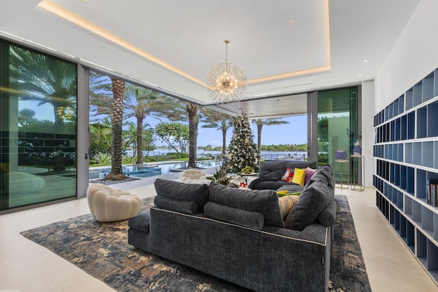 interior space featuring a chandelier, a raised ceiling, and floor to ceiling windows