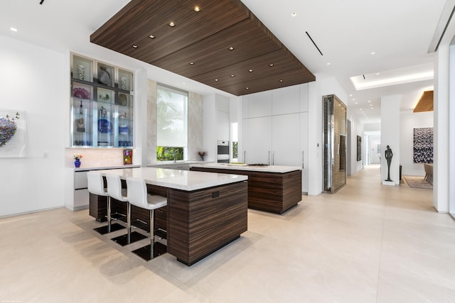 kitchen with dark brown cabinets, a center island, and a breakfast bar area