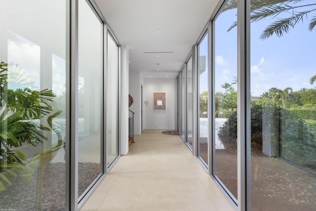 hall with plenty of natural light and a wall of windows