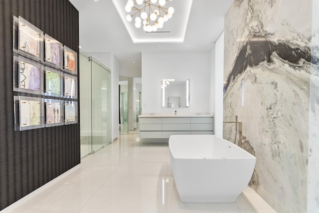 bathroom featuring vanity, a tray ceiling, separate shower and tub, and a notable chandelier