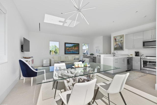 dining space with sink, light tile patterned floors, and a chandelier