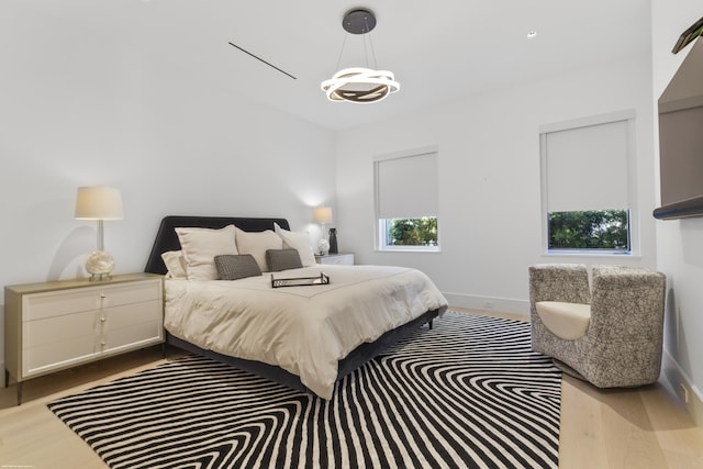 bedroom featuring light hardwood / wood-style floors and a chandelier