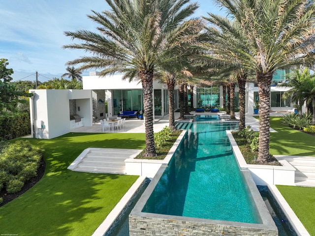 view of swimming pool featuring outdoor lounge area, a patio, and a lawn