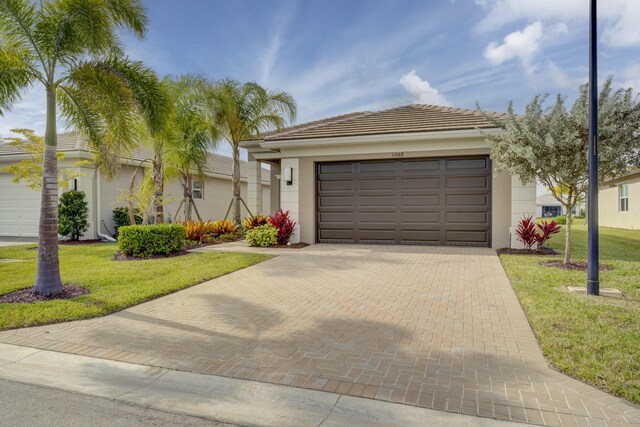 view of front of property with a garage and a front lawn