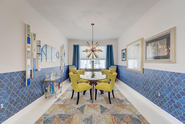 dining area with tile walls, a notable chandelier, and hardwood / wood-style floors