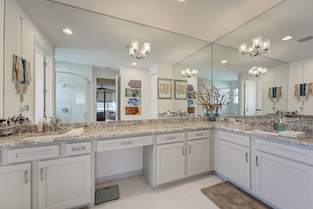 bathroom featuring vanity, a chandelier, and walk in shower