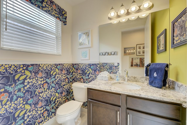 bathroom with vanity, tile walls, and toilet