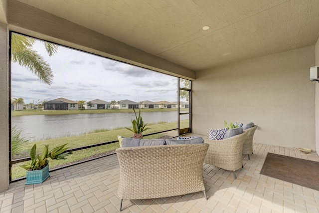 sunroom featuring a water view