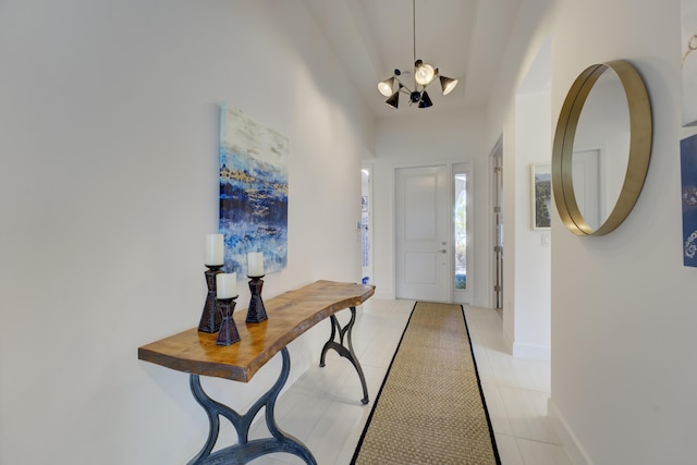 tiled entryway featuring an inviting chandelier