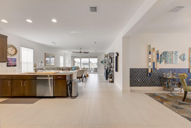 kitchen featuring stainless steel dishwasher, a healthy amount of sunlight, sink, and dark brown cabinetry