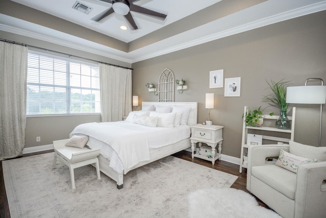 bedroom featuring hardwood / wood-style flooring, a raised ceiling, and ceiling fan